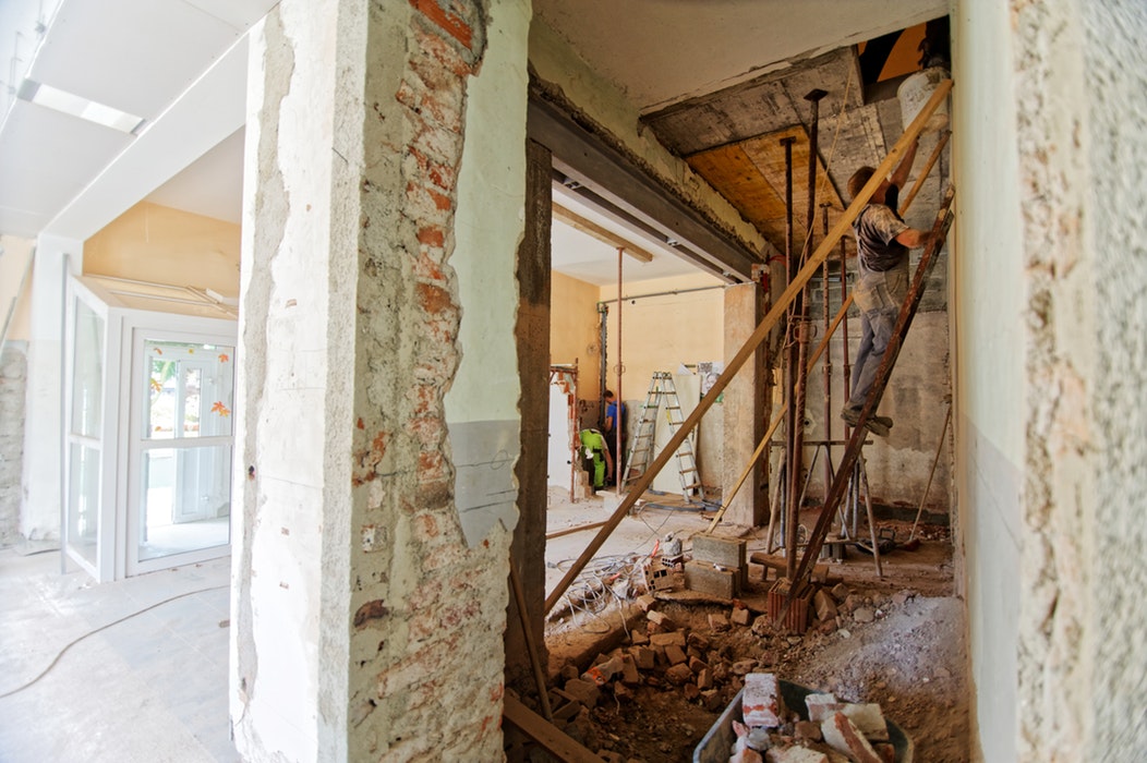 photo of home renovation workers working on a ladder inside the house